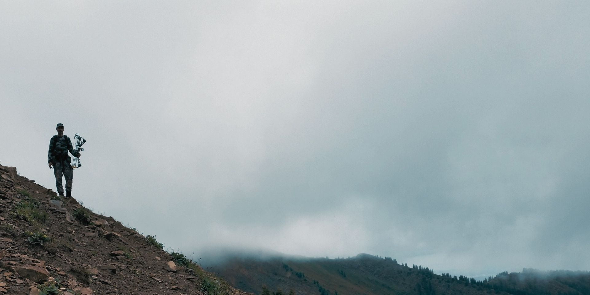 Guy hunting with a bow in the backcountry