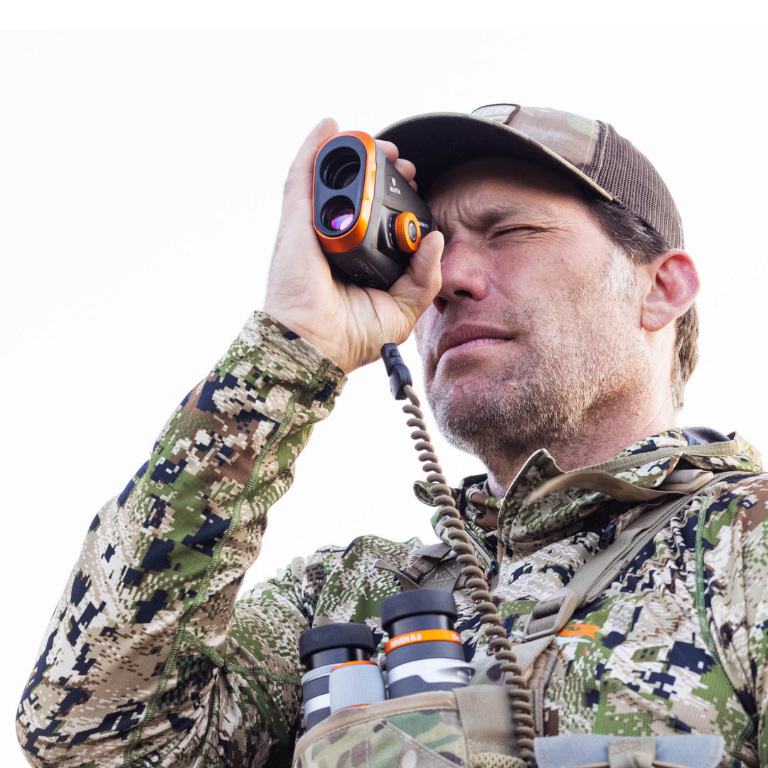 A master hunter holding Maven's RF.1 Rangefinder up to his eye